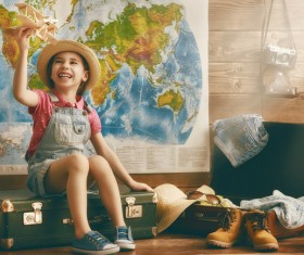 Little girl playing with toy airplane sitting on the table Stock Photo