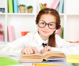 Little girl reading with glasses Stock Photo