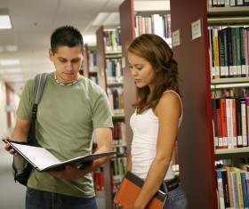 Male and female students talking in the library Stock Photo