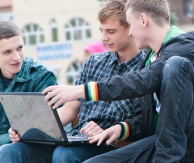 Male college students watching video together Stock Photo