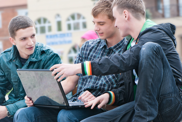 Male college students watching video together Stock Photo