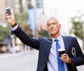 Man holding cellphone and coffee takes taxi Stock Photo