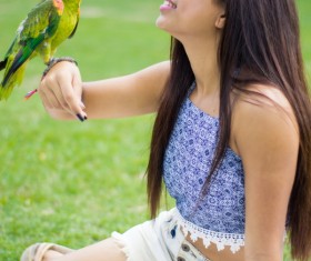 Parrot standing on the girls arm Stock Photo