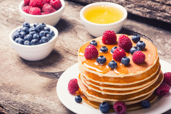 Raspberry blueberry pancakes with honey Stock Photo