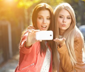 Sisters using smartphone selfie Stock Photo