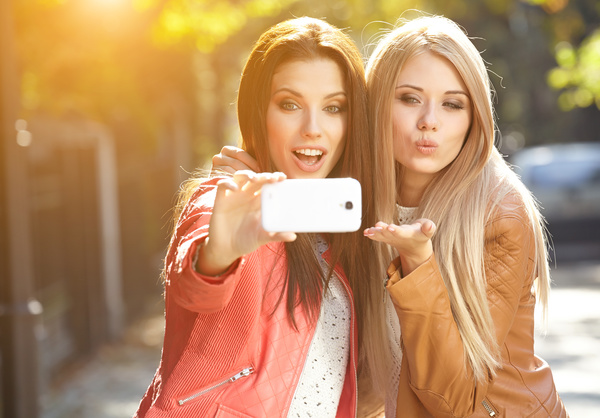 Sisters using smartphone selfie Stock Photo
