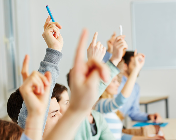 Students who raise their hands in class Stock Photo