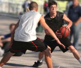 Teenagers playing basketball Stock Photo