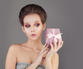 The girl with makeup holds the gift box Stock Photo