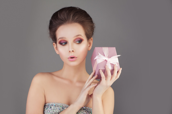 The girl with makeup holds the gift box Stock Photo