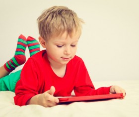 The little boy who plays the game on the bed Stock Photo