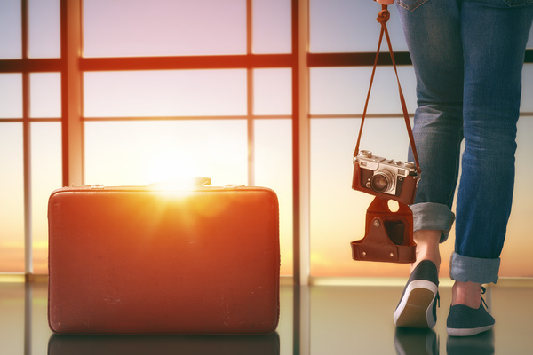 Woman holding camera and travel bag Stock Photo