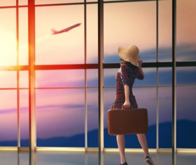 Woman holding travel bag in departure lounge Stock Photo