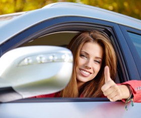 Woman sitting in the car with thumbs up Stock Photo