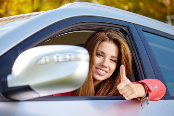 Woman sitting in the car with thumbs up Stock Photo