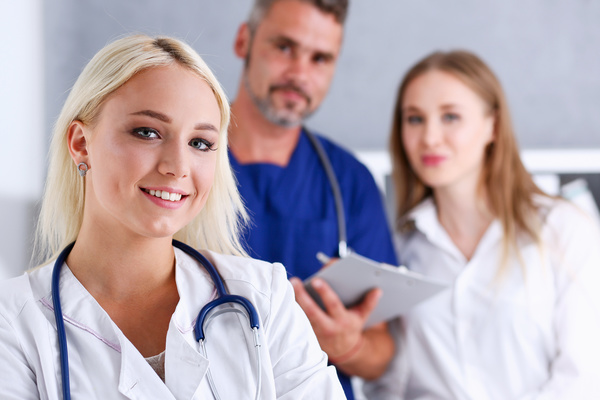 Young female doctor posing with colleague Stock Photo