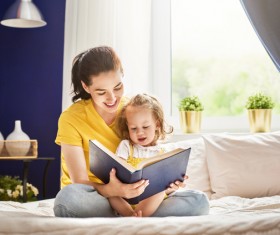 Young mother and daughter read together Stock Photo 01