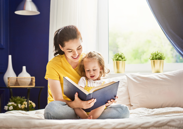 Young mother and daughter read together Stock Photo 01