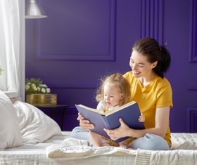 Young mother and daughter read together Stock Photo 02