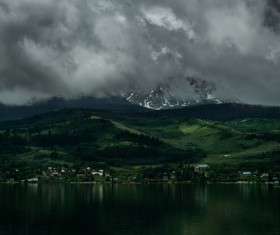 cloudscape above calm mountain lake scene Stock Photo
