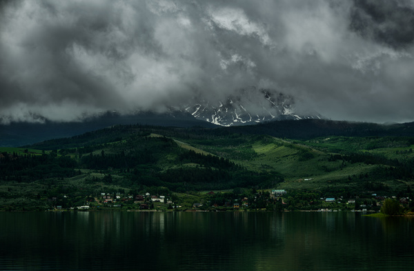 cloudscape above calm mountain lake scene Stock Photo