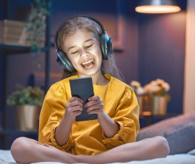 little girl listens to music with her Smartphone Stock Photo