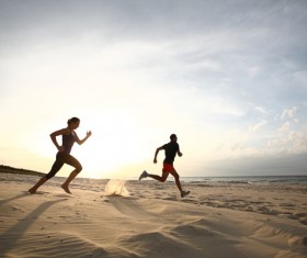 man and woman running on the beach Stock Photo