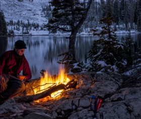 man resting beside the campfire Stock Photo