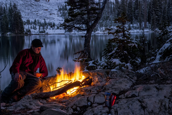 man resting beside the campfire Stock Photo