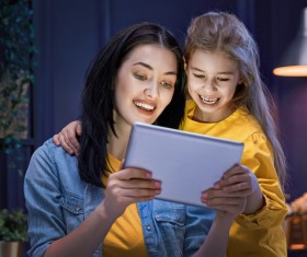 mother and her daughter girl are playing with tablet Stock Photo 01