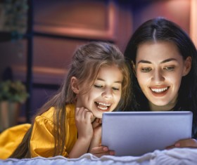 mother and her daughter girl are playing with tablet Stock Photo 02