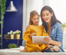 mother and her daughter girl are playing with tablet Stock Photo 04