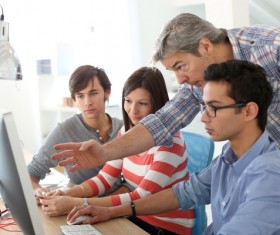 teacher who instructs students to operate a computer Stock Photo 01