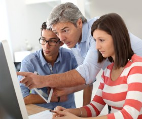 teacher who instructs students to operate a computer Stock Photo 02