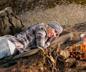 woman resting beside campfire Stock Photo