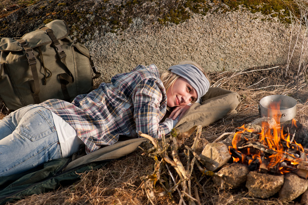 woman resting beside campfire Stock Photo