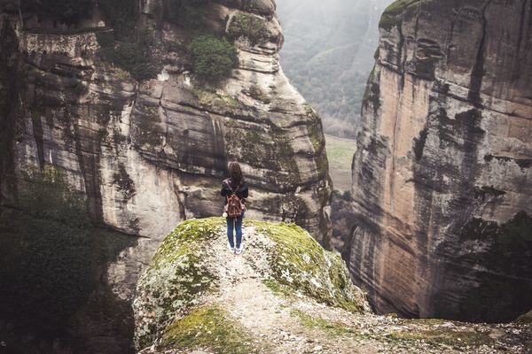 woman standing on the edge of cliff Stock Photo