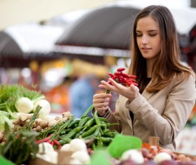 woman who buys chili in a vegetable stand Stock Photo
