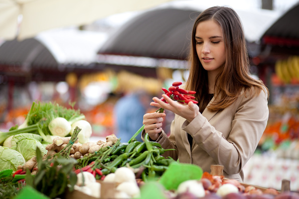woman who buys chili in a vegetable stand Stock Photo