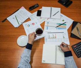 Businessman holding coffee sorting data Stock Photo