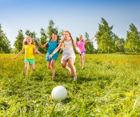 Children kicking the ball on the grass Stock Photo 01