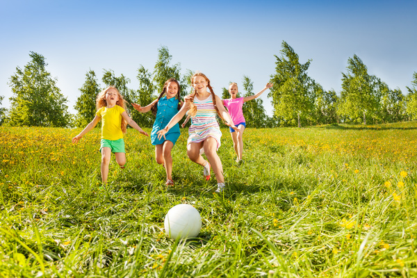 Children kicking the ball on the grass Stock Photo 01