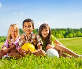 Children sitting on the grass Stock Photo