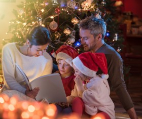 Christmas Eve family sitting together reading Stock Photo