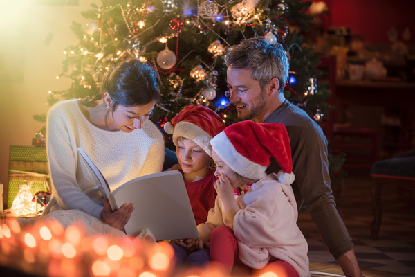 Christmas Eve family sitting together reading Stock Photo