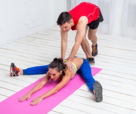 Coach helping the girl to stretch the waist Stock Photo
