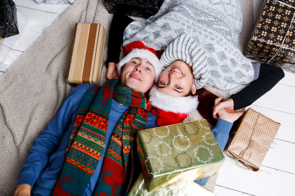 Couple wearing Santa hat lying on the floor Stock Photo
