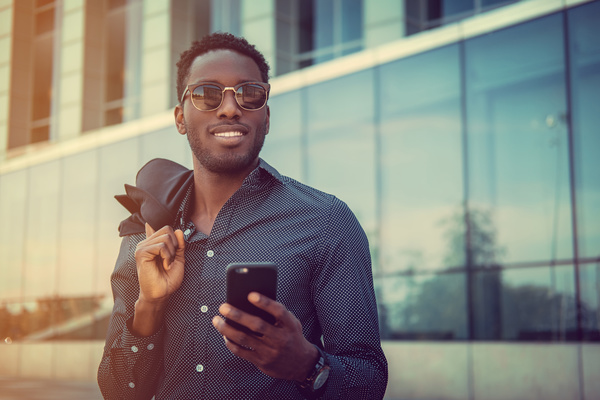 Dark-skinned man holding a cell phone Stock Photo
