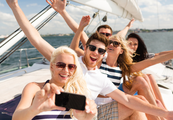 Friends on the yacht with a mobile phone selfie Stock Photo