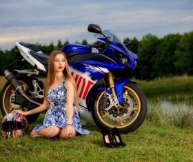 Girl and motorbike sitting on the grass Stock Photo